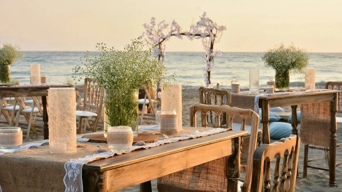 Seaside dinner tables set for a private celebration at golden hour