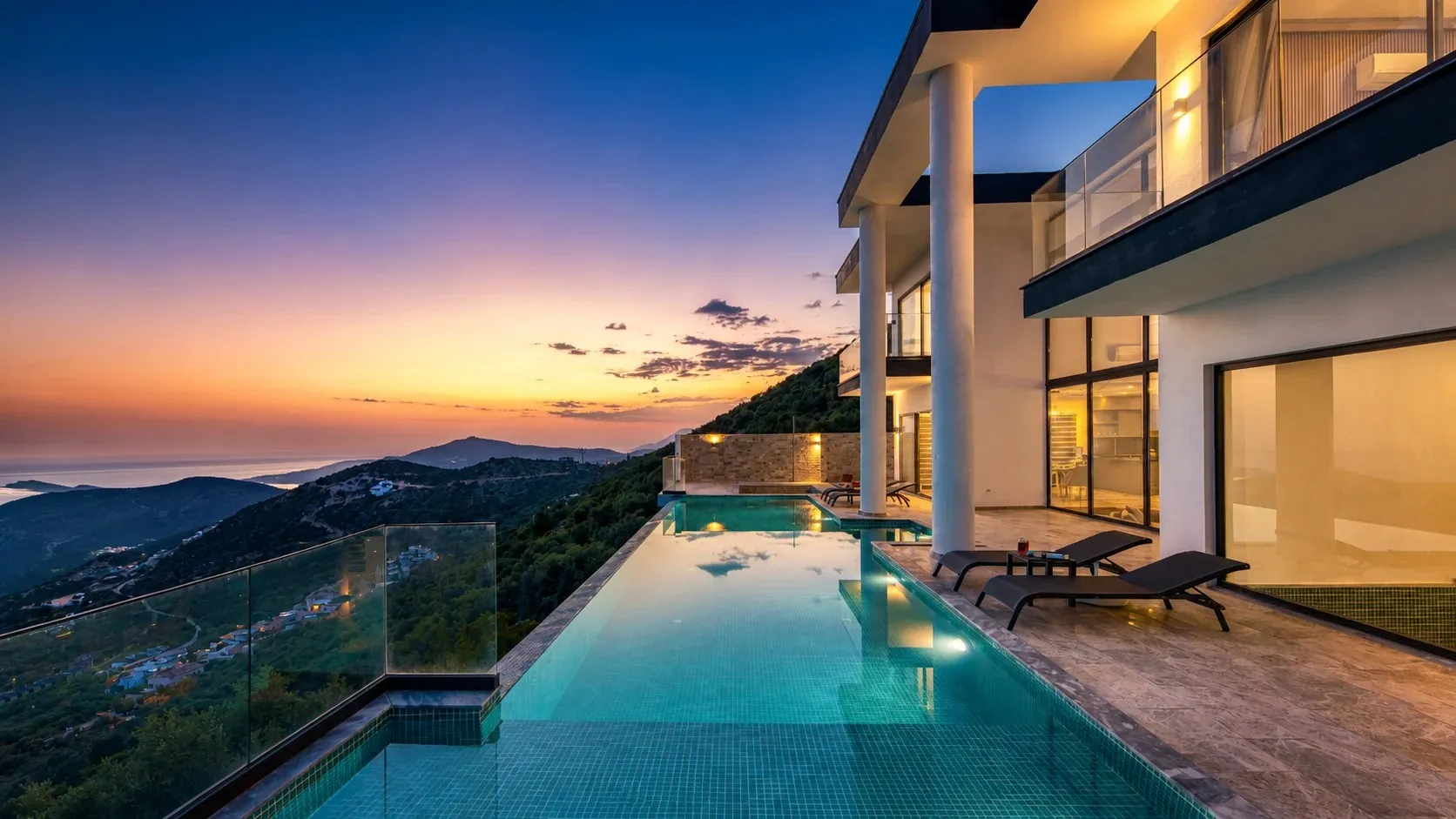 Hillside villa with infinity pool overlooking the sea at dusk