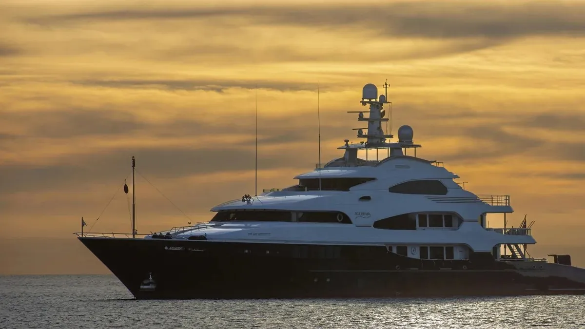 Superyacht at anchor off the Mallorcan coast under a golden sunset sky